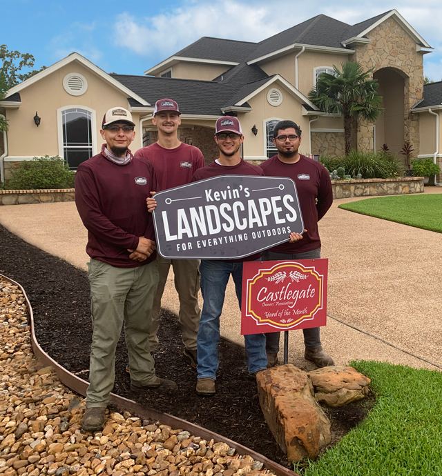 Three team members in front of a house holding the company logo