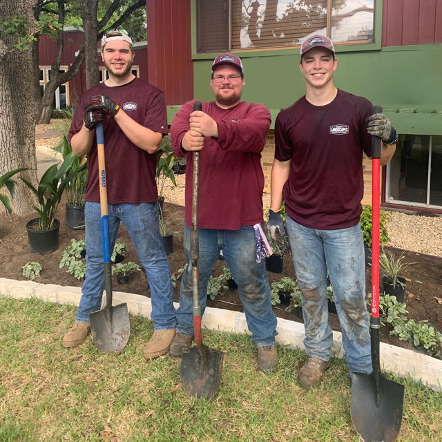 Three team members on site holding shovels